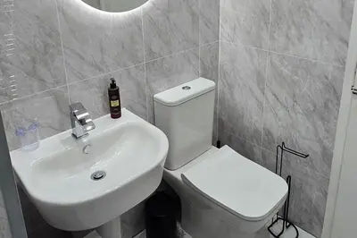 a bathroom with a white toilet and a sink at The Hideaway Cottage Feel Patio Central Parking in Southport