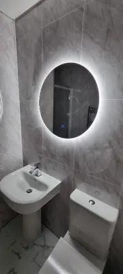 a bathroom with a sink and a mirror and a toilet at The Hideaway Cottage Feel Patio Central Parking in Southport