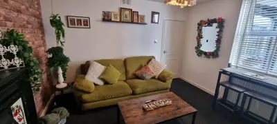 a living room with a couch and a table at The Hideaway Cottage Feel Patio Central Parking in Southport