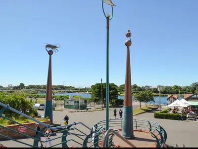 a park with a bench and two light poles at The Hideaway Cottage Feel Patio Central Parking in Southport