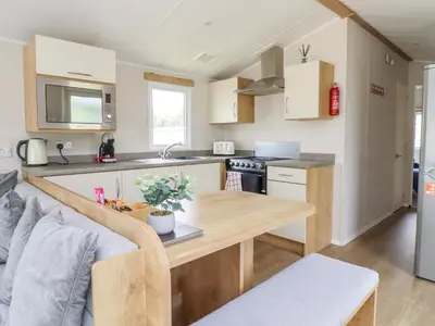 a kitchen with a wooden table in a room at Windermere Lodge in Morecambe
