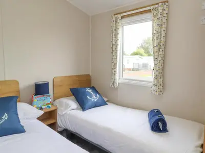 two beds in a room with a window at Windermere Lodge in Morecambe