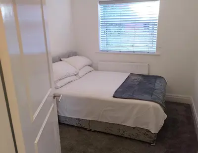 a small bedroom with a bed and a window at St Annes Lodge Garden Flat AWARD WINNING HOSTS in Lytham St Annes