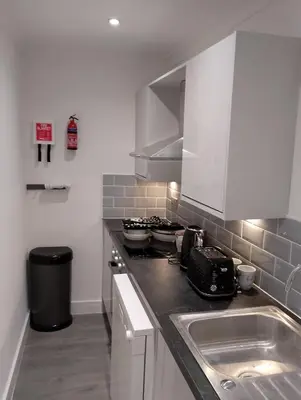 a kitchen with a sink and a stove top oven at St Annes Lodge Garden Flat AWARD WINNING HOSTS in Lytham St Annes