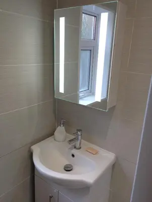 a bathroom with a white sink and a mirror at St Annes Lodge Garden Flat AWARD WINNING HOSTS in Lytham St Annes
