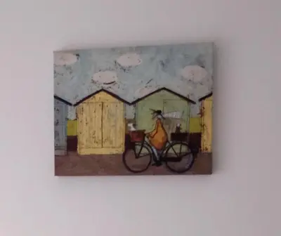 a painting of a woman on a bike on a wall at St Annes Lodge Garden Flat AWARD WINNING HOSTS in Lytham St Annes