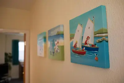 a wall with four pictures of boats on it at Half Moon Bay in Heysham