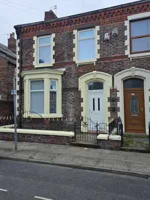 a brick house with a brown door on a street at Anfield Guest House Sleeps 5 in Liverpool