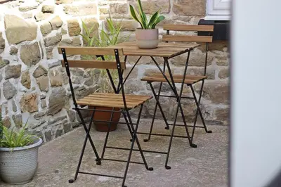 a wooden table with two chairs and a plant on it at Home in Chorley, Lancashire in Chorley