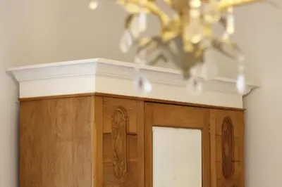 a chandelier is hanging over a wooden cabinet at Home in Chorley, Lancashire in Chorley