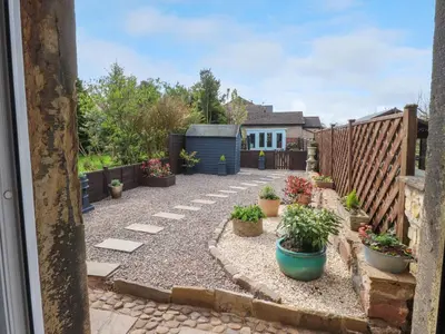 a garden with potted plants and a fence at 3 Cowper Place in Clitheroe