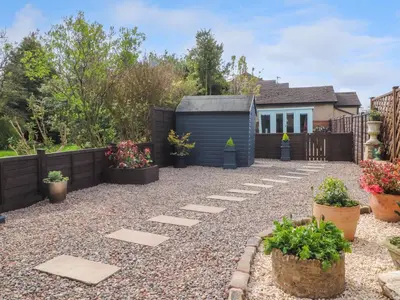 a garden with a blue shed and potted plants at 3 Cowper Place in Clitheroe