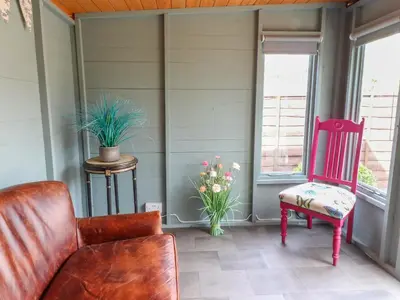 a porch with a couch and a chair and flowers at 3 Cowper Place in Clitheroe