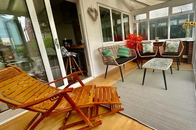 a porch with chairs and a bench on a porch at Charles Alexander Short Stay - Derbe House in Lytham St Annes