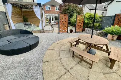 a patio with a picnic table and an umbrella at Charles Alexander Short Stay - Derbe House in Lytham St Annes