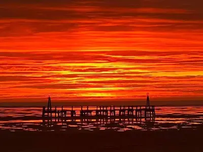 a pier on the beach with a sunset at Charles Alexander Short Stay - Derbe House in Lytham St Annes