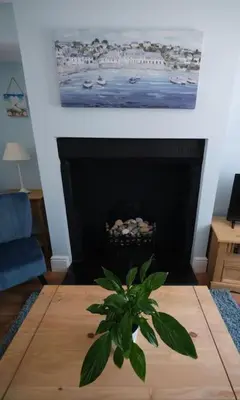 a living room with a fireplace with a plant on a table at Olivia Cottage - a Home From Home by the Sea in Morecambe