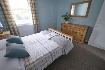 a bedroom with a bed and a mirror and a dresser at Olivia Cottage - a Home From Home by the Sea in Morecambe