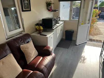a living room with a couch and a microwave at The Hideaway in Ainsdale