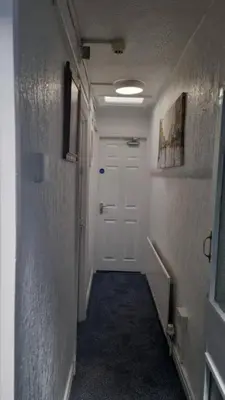 a hallway with a white door and a white hallway sidx sidx sidx at Pinnacle Hotel & Suites formerly Jean Martyn Hotel Near Central Blackpool, Near Beach & Attractions in Blackpool