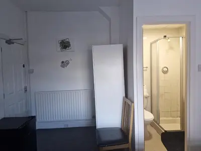 a white bathroom with a toilet and a shower at Pinnacle Hotel & Suites formerly Jean Martyn Hotel Near Central Blackpool, Near Beach & Attractions in Blackpool
