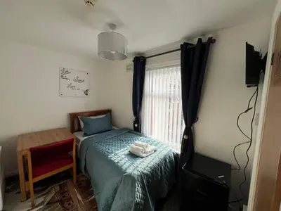 a small bedroom with a bed and a window at Pinnacle Hotel & Suites formerly Jean Martyn Hotel Near Central Blackpool, Near Beach & Attractions in Blackpool