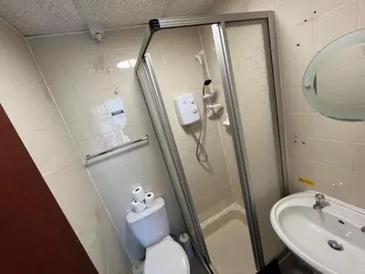 a bathroom with a shower and a toilet and a sink at Pinnacle Hotel & Suites formerly Jean Martyn Hotel Near Central Blackpool, Near Beach & Attractions in Blackpool