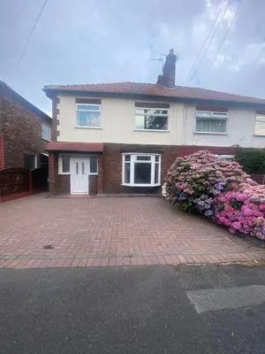 a house with a brick driveway with flowers at Lovely 3 bed house in Crosby in Crosby