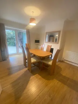 a dining room with a wooden table and chairs at Lovely 3 bed house in Crosby in Crosby