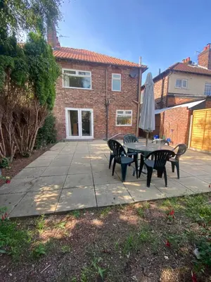 a patio with a table and chairs and an umbrella at Lovely 3 bed house in Crosby in Crosby