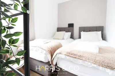 two beds in a room with a mirror at Phoenix Rise in Fleetwood