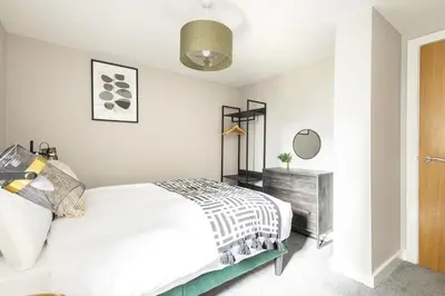 a white bedroom with a bed and a mirror at Host & Stay - The Pall Mall Apartment in Liverpool