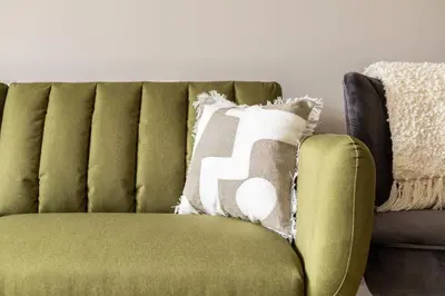 a green couch with a pillow on it at Host & Stay - The Pall Mall Apartment in Liverpool