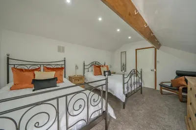 a bedroom with a large bed with orange pillows at Casbah Coffee Club Suites in West Derby