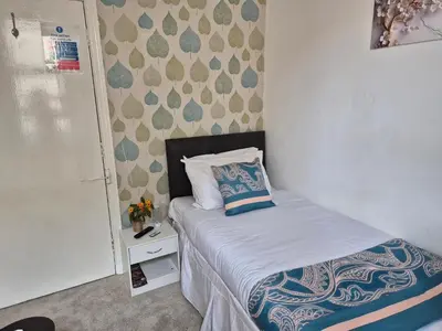 a small bedroom with a bed with a pillow on it at Glendor Hotel in Blackpool
