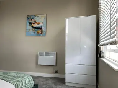 a bedroom with a painting of a boat on the wall at Gorgeous Quarter House Apartment in Liverpool