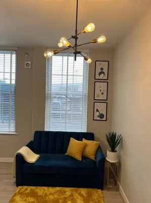 a blue couch in a living room with a chandelier at Gorgeous Quarter House Apartment in Liverpool