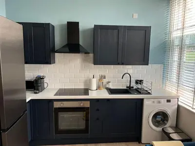 a kitchen with a sink and a washing machine at Gorgeous Quarter House Apartment in Liverpool