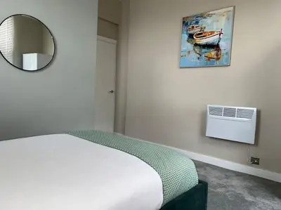 a bedroom with a bed and a mirror and a window at Gorgeous Quarter House Apartment in Liverpool