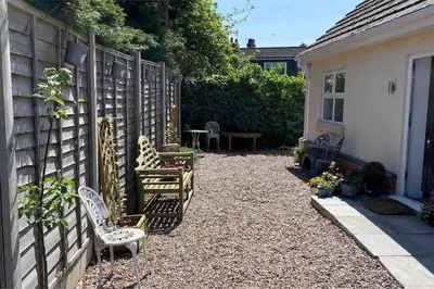 a backyard with chairs and a table and a fence at Helens Haven First floor apartment via stairs in Preston