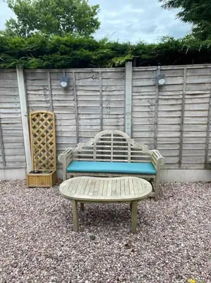 a bench and a stool in front of a fence at Helens Haven First floor apartment via stairs in Preston