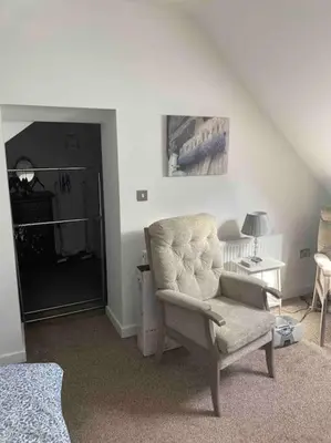 a living room with a chair and a lamp at Helens Haven First floor apartment via stairs in Preston