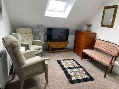 a living room with two chairs and a tv at Helens Haven First floor apartment via stairs in Preston