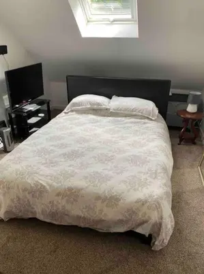 a bedroom with a large bed with a white comforter at Helens Haven First floor apartment via stairs in Preston