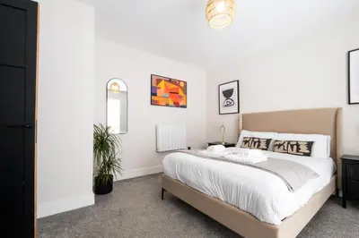 a bedroom with a large bed and a potted plant at Luxury 4BDR House By Torr Property Group Short Lets & Serviced Accommodation With Free Gated Secure Parking & Private Patio Garden Liverpool in Liverpool