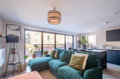 a living room with a blue couch and a kitchen at Luxury 4BDR House By Torr Property Group Short Lets & Serviced Accommodation With Free Gated Secure Parking & Private Patio Garden Liverpool in Liverpool