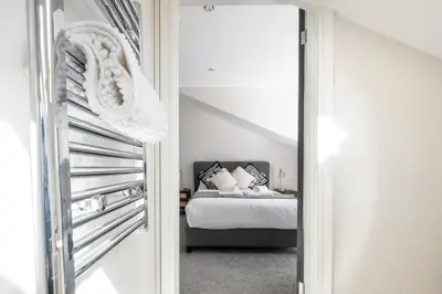 a bedroom with a bed and a mirror at Luxury 4BDR House By Torr Property Group Short Lets & Serviced Accommodation With Free Gated Secure Parking & Private Patio Garden Liverpool in Liverpool