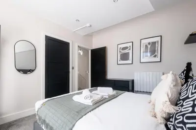 a bedroom with a white bed with a mirror at Luxury 4BDR House By Torr Property Group Short Lets & Serviced Accommodation With Free Gated Secure Parking & Private Patio Garden Liverpool in Liverpool