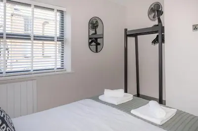 a bedroom with a bed and a mirror and a window at Luxury 4BDR House By Torr Property Group Short Lets & Serviced Accommodation With Free Gated Secure Parking & Private Patio Garden Liverpool in Liverpool
