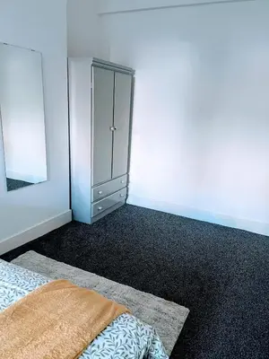 a bedroom with a bed and a mirror at Bay Wind Apartment in Morecambe